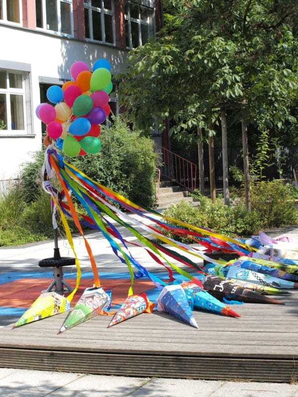 Schultüte mit Luftballons auf Pausenhof