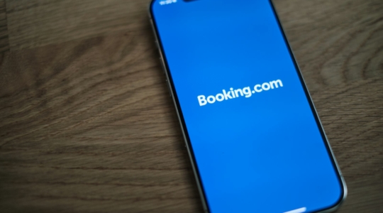 Smartphone mit geöffnetem Logo von Booking.com auf dem Bildschirm