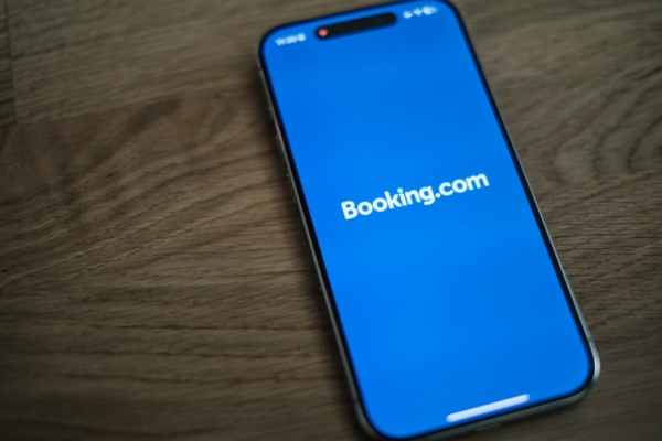 Smartphone mit geöffnetem Logo von Booking.com auf dem Bildschirm
