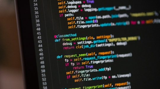 Laptop-Bildschirm mit farbigem Programmcode als Symbol für KI-generierte Software