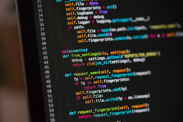Laptop-Bildschirm mit farbigem Programmcode als Symbol für KI-generierte Software